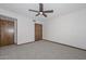 Cozy bedroom featuring neutral carpeting and simple décor, including a ceiling fan and closet at 13014 N 23Rd Pl, Phoenix, AZ 85022
