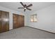 Comfortable bedroom featuring carpet flooring, wood doors, and a ceiling fan for added comfort at 13014 N 23Rd Pl, Phoenix, AZ 85022