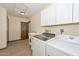 Spacious laundry room features tile flooring, utility sink, washer, dryer, and storage cabinets at 13014 N 23Rd Pl, Phoenix, AZ 85022