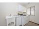 Bright laundry room features tile flooring, utility sink, washer, and dryer at 13014 N 23Rd Pl, Phoenix, AZ 85022