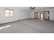 Bright living room with large windows and ceiling fan, leading to the next room through glass-paneled doors at 13014 N 23Rd Pl, Phoenix, AZ 85022