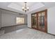 Open-concept living room featuring tile flooring, wooden doors, and views of the backyard through a large window at 13014 N 23Rd Pl, Phoenix, AZ 85022