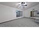 Spacious living room with neutral carpet, ceiling fan, and view into another room through an arched doorway at 13014 N 23Rd Pl, Phoenix, AZ 85022