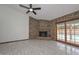 Open living room featuring a brick fireplace and sliding glass doors to the pool area at 13014 N 23Rd Pl, Phoenix, AZ 85022