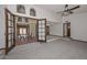 Open living room with high ceiling, carpet flooring, ceiling fan, and french doors at 13014 N 23Rd Pl, Phoenix, AZ 85022