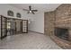 Bright room with a ceiling fan and glass doors leading to a table and chairs near a brick fireplace at 13014 N 23Rd Pl, Phoenix, AZ 85022