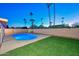 Backyard showcasing a lit pool, green lawn, and privacy fencing at 13014 N 23Rd Pl, Phoenix, AZ 85022