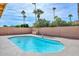 Backyard features a refreshing pool, palm trees, and desert landscaping for a relaxing outdoor space at 13014 N 23Rd Pl, Phoenix, AZ 85022