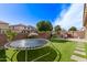 Lush backyard with artificial turf, trampoline, and shaded seating area at 13225 W Rowel Rd, Peoria, AZ 85383