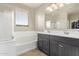 The bright bathroom features a shower, soaking tub, double vanity and view to the closet at 13225 W Rowel Rd, Peoria, AZ 85383