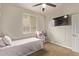 This cute bedroom features a ceiling fan, TV and window for natural light at 13225 W Rowel Rd, Peoria, AZ 85383