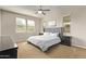 Comfortable main bedroom featuring a decorative headboard, ceiling fan, and plenty of natural light at 13225 W Rowel Rd, Peoria, AZ 85383