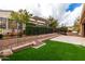 Well maintained backyard with artificial turf, built-in BBQ, and wrought iron fence at 1407 E Artemis Trl, San Tan Valley, AZ 85140