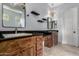 Bathroom featuring dual sinks with granite countertops, wooden cabinetry and chandelier lighting at 1407 E Artemis Trl, San Tan Valley, AZ 85140