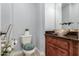 Powder room featuring a wood vanity, vessel sink, decorative mirror, and stylish finishes at 1407 E Artemis Trl, San Tan Valley, AZ 85140