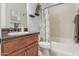 Bathroom with a shower-tub combo, wood cabinets, and neutral decor; features good storage and natural light at 1407 E Artemis Trl, San Tan Valley, AZ 85140