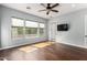 Bright bedroom showcasing hardwood floors, three large windows and access to patio at 1407 E Artemis Trl, San Tan Valley, AZ 85140