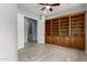 Spacious bedroom with tile flooring, built-in wood shelving, and neutral paint at 1407 E Artemis Trl, San Tan Valley, AZ 85140
