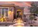 Inviting home exterior with illuminated entry stairs, desert landscaping, and a charming front gate at 1407 E Artemis Trl, San Tan Valley, AZ 85140