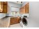 Laundry room featuring wooden cabinetry, granite countertops, and front-loading machines at 1407 E Artemis Trl, San Tan Valley, AZ 85140