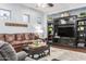 Comfortable living room with a brown leather sofa, black entertainment center, and neutral decor at 1407 E Artemis Trl, San Tan Valley, AZ 85140