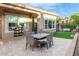 Outdoor patio featuring dining table with seating, manicured lawn and cafe umbrella at 1407 E Artemis Trl, San Tan Valley, AZ 85140