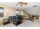 Bright upstairs bonus living area with soft carpet, ceiling fan, and large windows at 16055 W Anasazi St, Goodyear, AZ 85338