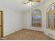 A carpeted bedroom with arched windows with shutters and a ceiling fan with lights at 16522 E Glenbrook Blvd, Fountain Hills, AZ 85268