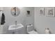 Bright powder room with a pedestal sink, toilet, and decorative artwork on the wall at 16522 E Glenbrook Blvd, Fountain Hills, AZ 85268
