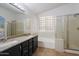 Bathroom showcasing double sinks, granite countertops, a combination tub and shower, and tile floors at 17201 N Chance Dr, Surprise, AZ 85374