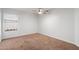A well-lit bedroom includes neutral carpet, ceiling fan, and window at 17201 N Chance Dr, Surprise, AZ 85374