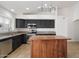 Well-lit kitchen includes stainless steel appliances, dark cabinets, and center butcher block island at 17201 N Chance Dr, Surprise, AZ 85374