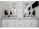 Bright bathroom featuring double sinks, granite counters, white cabinetry, and a wall-mounted TV at 19700 N 76Th St # 2044, Scottsdale, AZ 85255