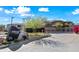 Gated community entrance featuring stone signage, landscaping, and colorful bougainvillea at 19700 N 76Th St # 2044, Scottsdale, AZ 85255