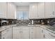 Updated kitchen features white cabinets, stylish backsplash, and stainless steel sink at 19700 N 76Th St # 2044, Scottsdale, AZ 85255