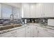 Stainless steel sink and faucet with granite countertops, mosaic backsplash and white cabinets at 19700 N 76Th St # 2044, Scottsdale, AZ 85255