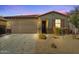 Single-story home at dusk featuring a brown garage door and desert landscaping at 20056 N 107Th Ln, Peoria, AZ 85373