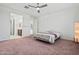 Main bedroom featuring plush carpet, a ceiling fan, and ensuite bathroom access at 20056 N 107Th Ln, Peoria, AZ 85373