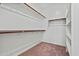 Spacious walk-in closet featuring carpeted floors and wooden rails with white shelving at 20056 N 107Th Ln, Peoria, AZ 85373