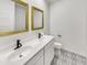 Stylish bathroom featuring double sinks, gold-framed mirrors, and patterned tile flooring at 2181 W Harmont Dr, Phoenix, AZ 85021