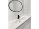 Elegant bathroom featuring a modern sink, sleek faucet, and stylish round mirror at 2181 W Harmont Dr, Phoenix, AZ 85021