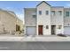 View of townhome with gray stucco, white trim, brown door, garage, and rock landscaping at 2181 W Harmont Dr, Phoenix, AZ 85021