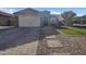 Charming home featuring a two-car garage, low maintenance landscaping, and a stone paver driveway and walkway at 2297 E Mews Rd, Gilbert, AZ 85298