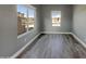 Bright, airy living room with modern gray walls, wood-look flooring, and large windows for plenty of natural light at 2297 E Mews Rd, Gilbert, AZ 85298