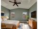 Comfortable bedroom with high ceilings, hardwood floors, ceiling fan, and natural light from dual windows at 2297 E Mews Rd, Gilbert, AZ 85298