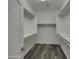 Spacious walk-in closet with wood floor and built-in shelving, providing ample storage at 2297 E Mews Rd, Gilbert, AZ 85298