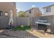 Fenced backyard featuring synthetic lawn, rocks, a grill, and an umbrella at 2367 W Dusty Wren Dr, Phoenix, AZ 85085