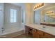 Bright bathroom featuring dual sinks, a soaking tub, and stylish lighting at 2367 W Dusty Wren Dr, Phoenix, AZ 85085