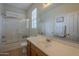 Bathroom featuring a white sink and shower over bath with glass sliding doors and plenty of natural light at 2367 W Dusty Wren Dr, Phoenix, AZ 85085