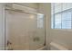 Bathroom with a tiled shower over bath, glass screen, window, and toilet at 2367 W Dusty Wren Dr, Phoenix, AZ 85085